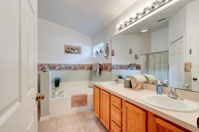 a bathroom with a double vanity sink mirror and bathtub