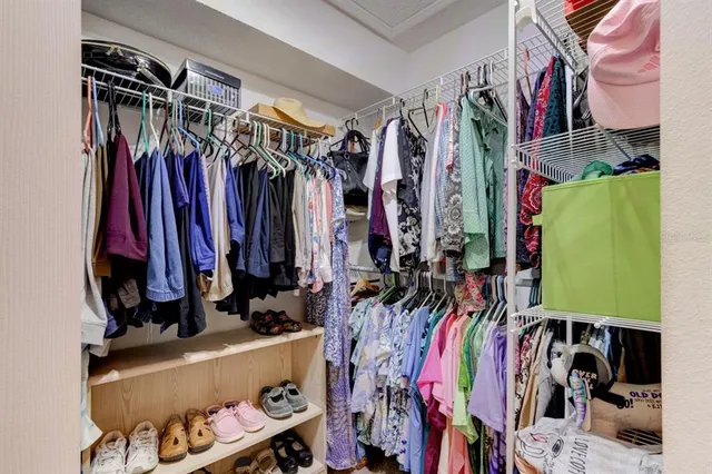 a view of walk in closet with clothes