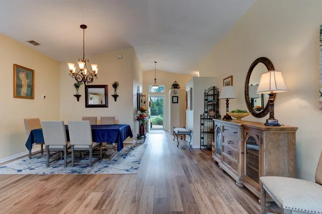 a view of a dining room with furniture a chandelier and wooden floor