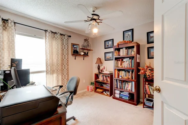 a view of a workspace with furniture and a window
