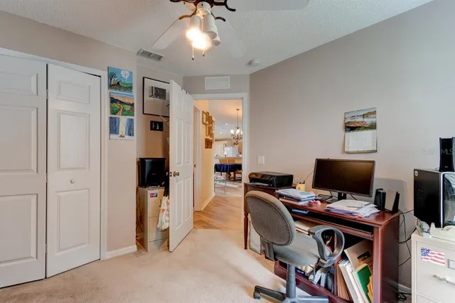 a view of a workspace with furniture and a window