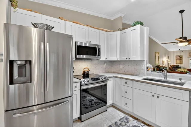 a kitchen with a refrigerator sink and white cabinets