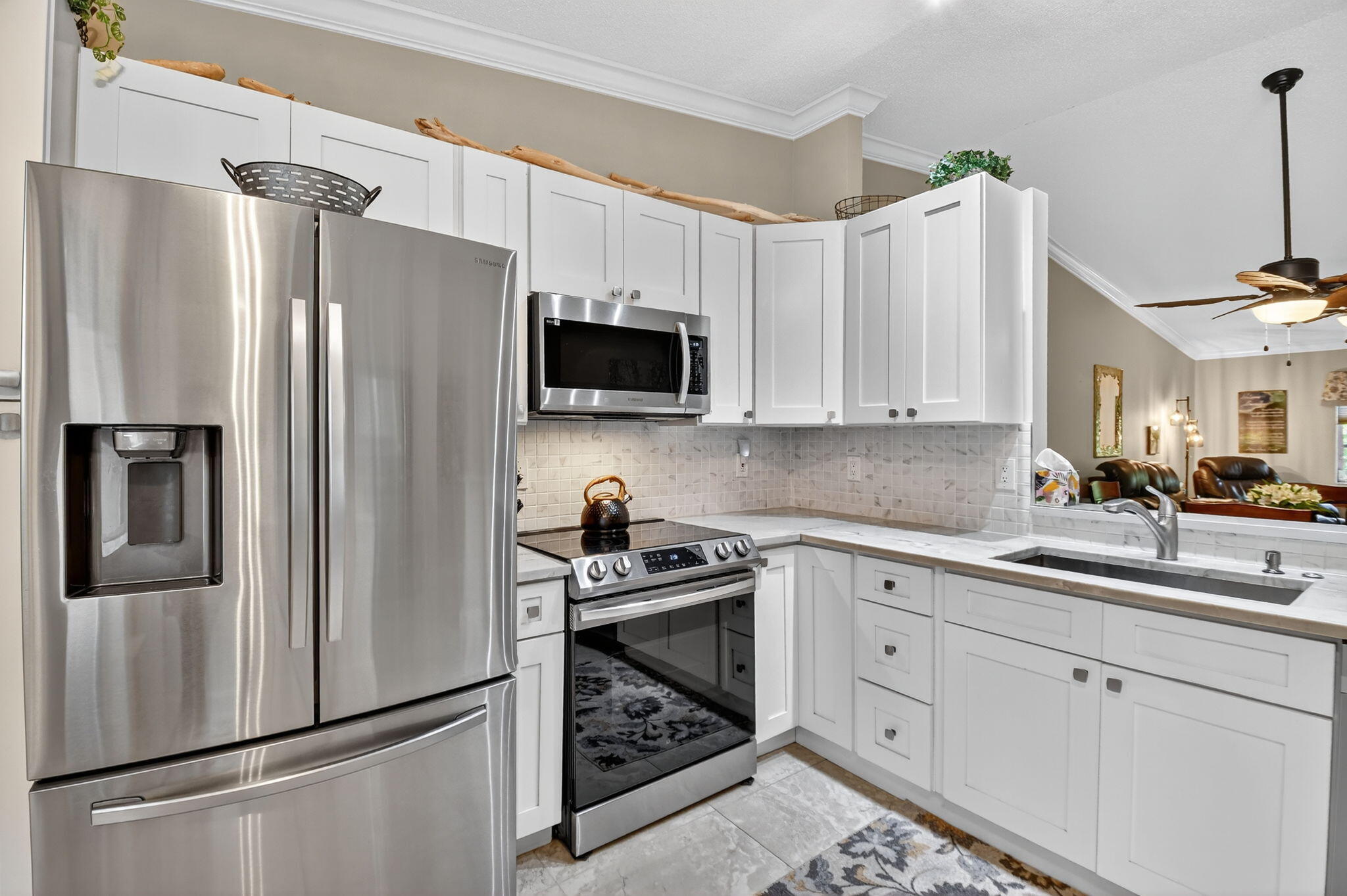6426 Mill Pointe Circle Delray Beach, FL 33484 - Photo 12 of 57 a kitchen with a refrigerator sink and white cabinets