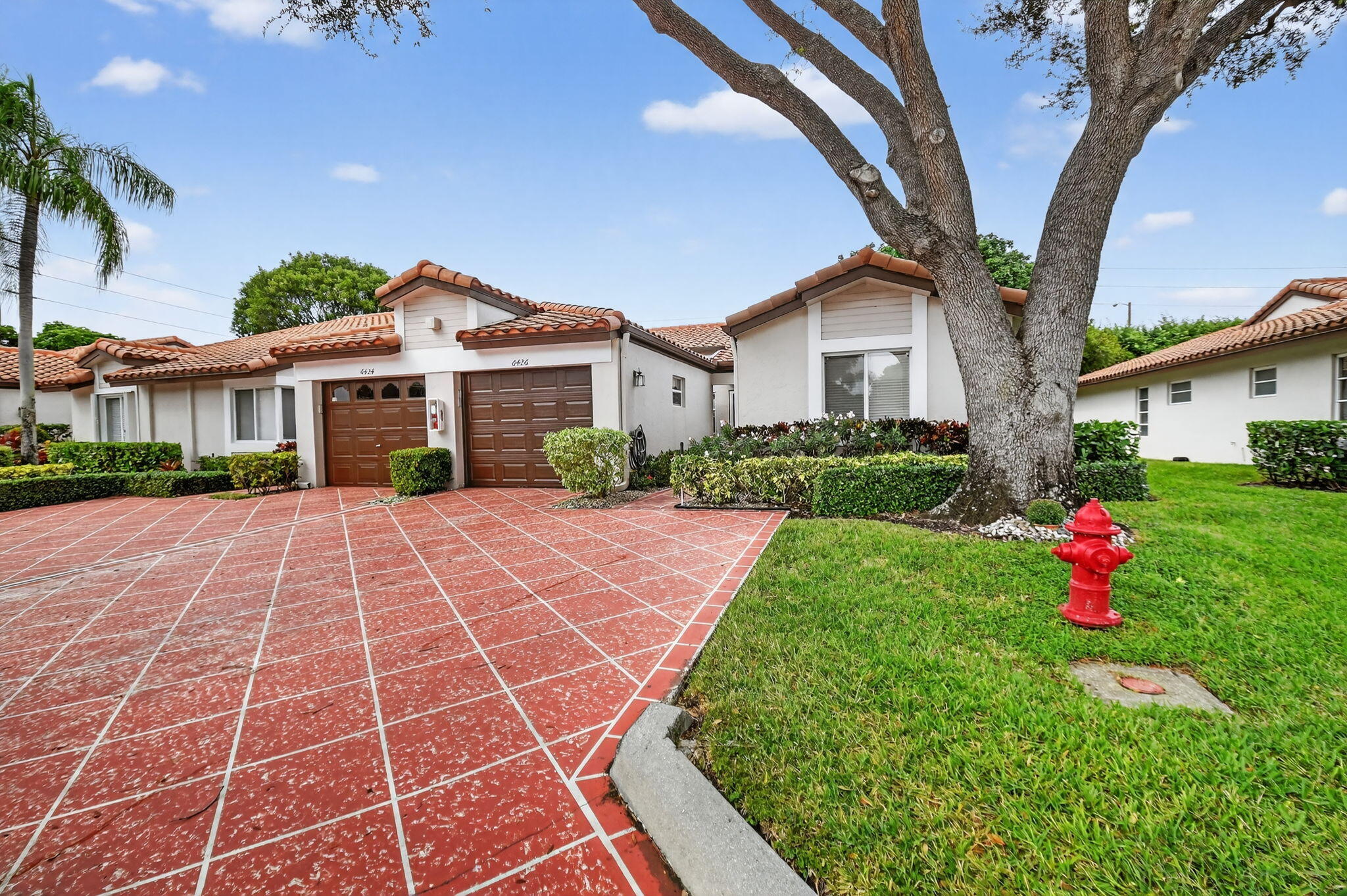 6426 Mill Pointe Circle Delray Beach, FL 33484 - Photo 33 of 57 a front view of a house with a yard and potted plants