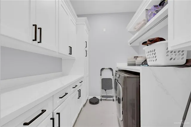 a kitchen with white cabinets and appliances