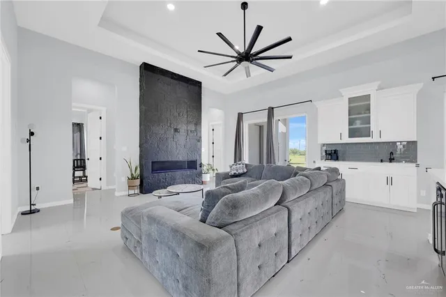 a living room with furniture a ceiling fan and a large window