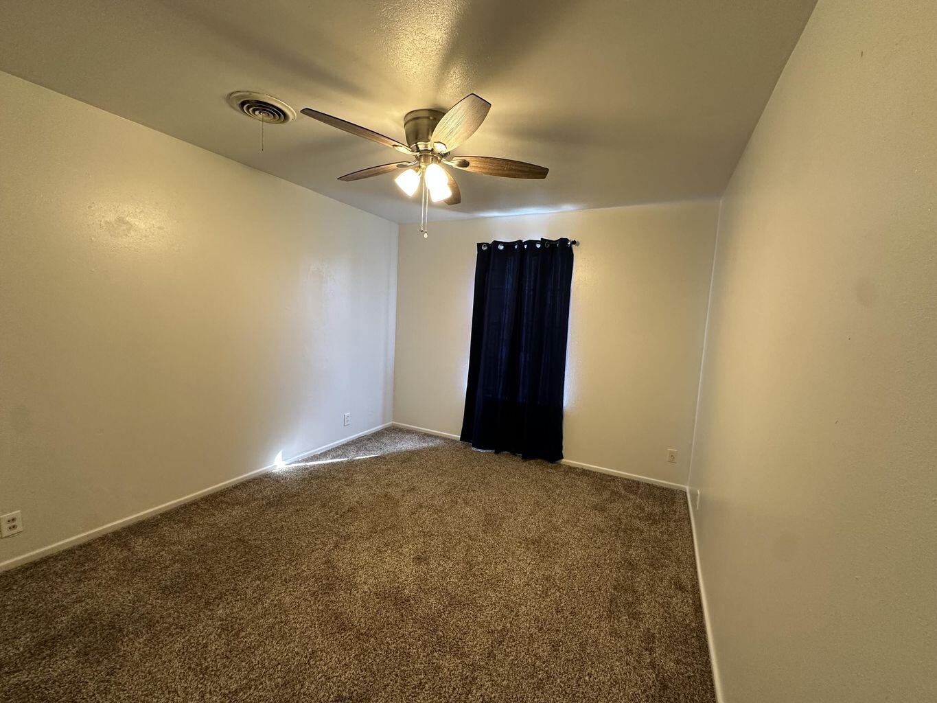 2807 Lexington Street Plainview, TX 79072 - Photo 13 of 16 an empty room with a ceiling fan and a window