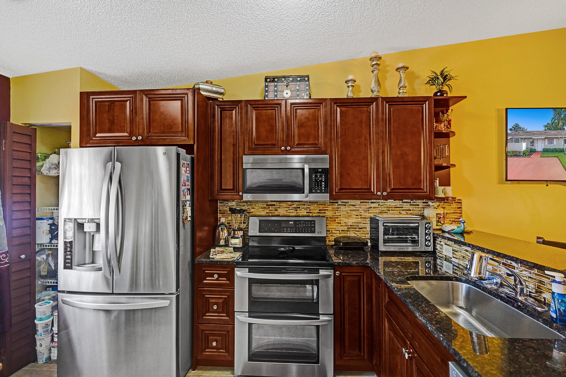 8624 Overset Lane, Unit B Boca Raton, FL 33496 - Photo 19 of 29 a kitchen with a refrigerator and a stove top oven