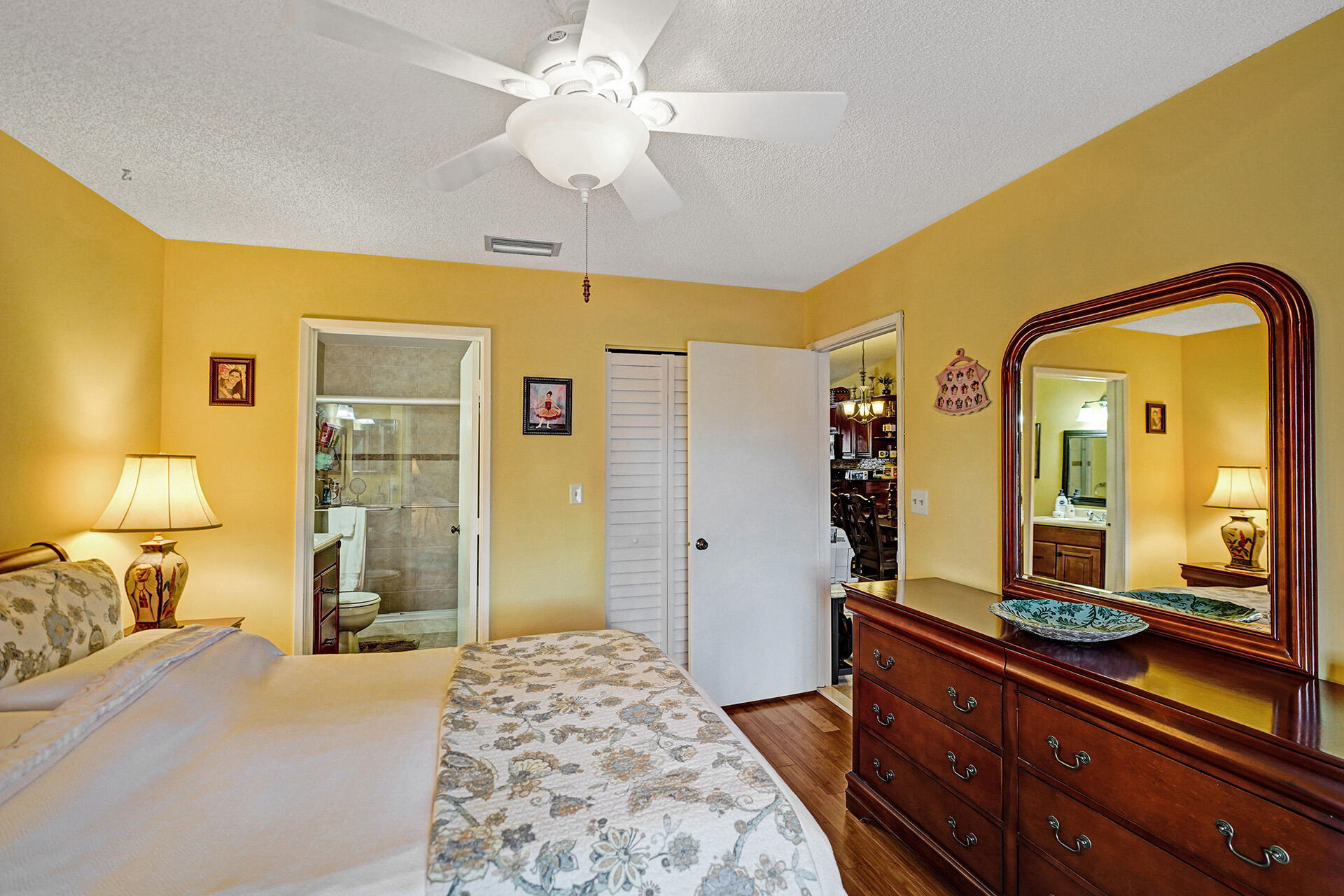 8624 Overset Lane, Unit B Boca Raton, FL 33496 - Photo 3 of 29 a bedroom with a bed and a dresser with mirror
