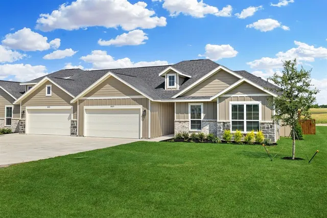 a front view of a house with a yard and trees