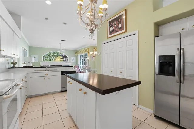 a kitchen with stainless steel appliances granite countertop a sink and dishwasher a refrigerator with white cabinets