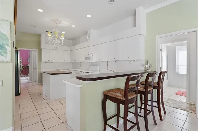 a kitchen with stainless steel appliances kitchen island granite countertop a table and chairs in it