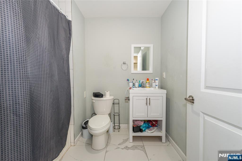 59 Mercer Street Paterson, NJ 07524 - Photo 14 of 15 a bathroom with a toilet sink and mirror