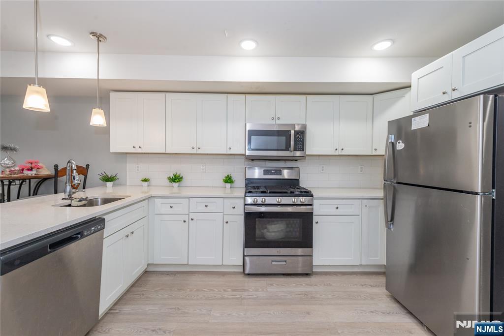 59 Mercer Street Paterson, NJ 07524 - Photo 4 of 15 a kitchen with cabinets stainless steel appliances and a sink
