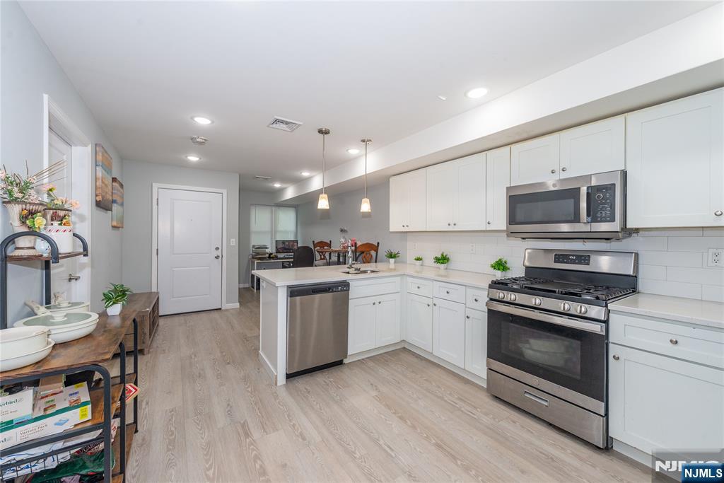 59 Mercer Street Paterson, NJ 07524 - Photo 5 of 15 a kitchen with a sink stainless steel appliances and white cabinets