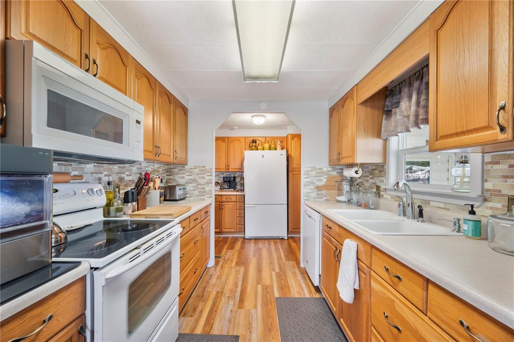 1610 Reynolds Road, Unit 187 Lakeland, FL 33801 - Photo 3 of 20 a kitchen with stainless steel appliances granite countertop a sink a stove and a wooden floors