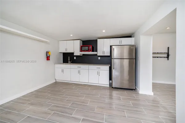 a kitchen with a refrigerator a microwave and sink