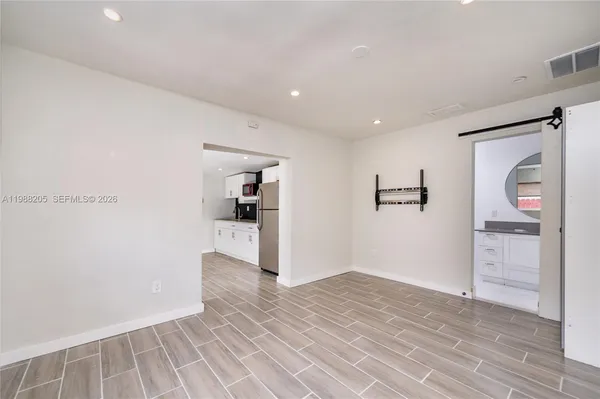 a view of a hallway with wooden floor and closet