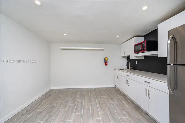 a kitchen with cabinets and wooden floor