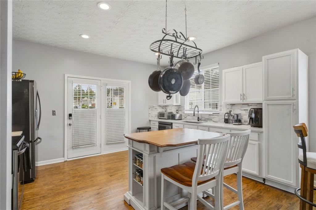 3635 Roseman Landing Cumming, GA 30040 - Photo 5 of 31 a kitchen with a dining table chairs sink and cabinets