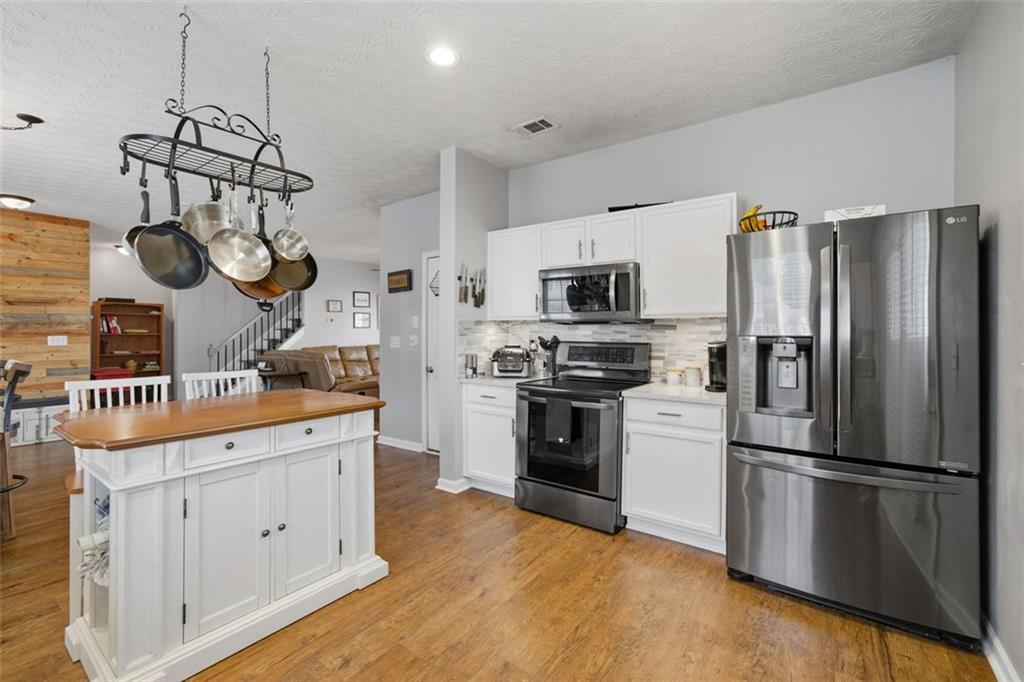 3635 Roseman Landing Cumming, GA 30040 - Photo 6 of 31 a kitchen with stainless steel appliances granite countertop a refrigerator a stove and a sink