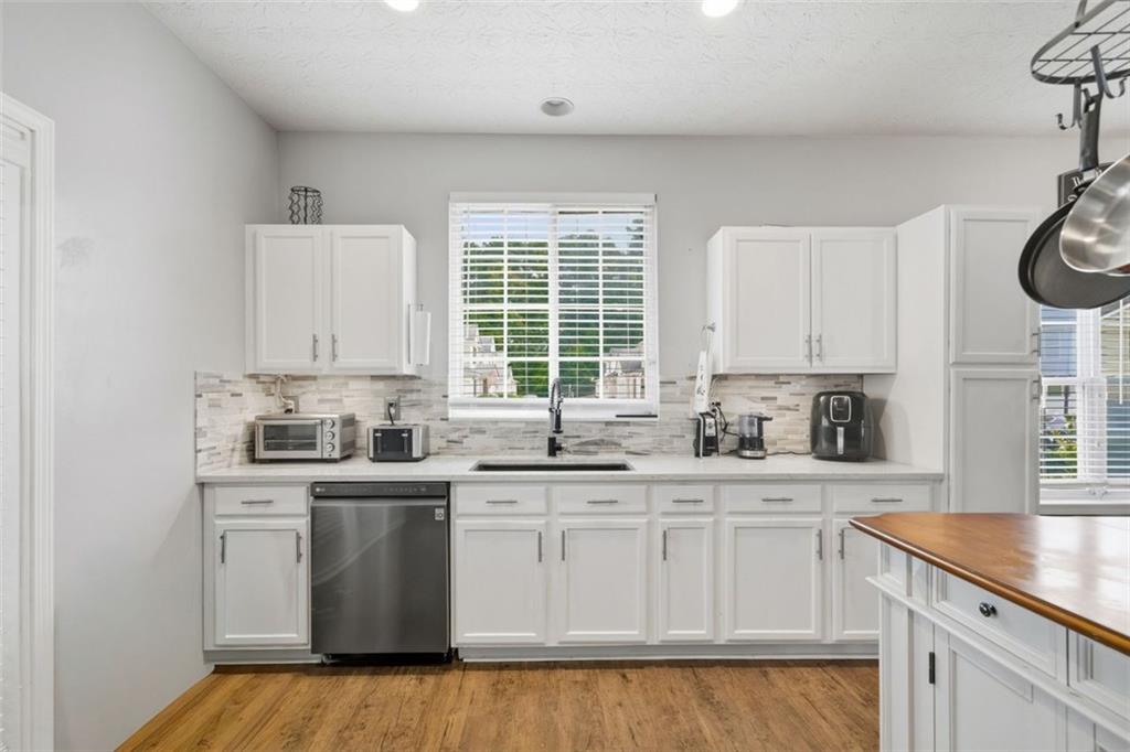 3635 Roseman Landing Cumming, GA 30040 - Photo 7 of 31 a kitchen with granite countertop white cabinets and white appliances