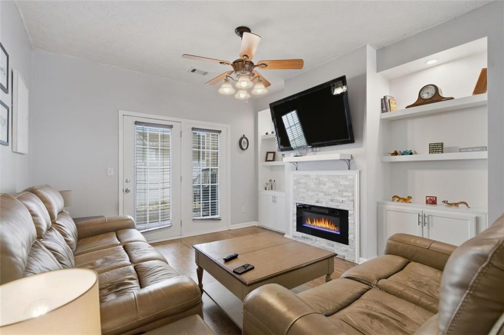 3635 Roseman Landing Cumming, GA 30040 - Photo 8 of 31 a living room with furniture a flat screen tv and a fireplace