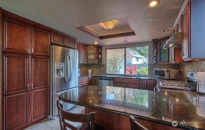 9502 South 200th Street Kent, WA 98031 - Photo 6 of 21 a kitchen with a refrigerator and a stove top oven