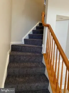 a view of a livingroom with wooden floor and kitchen