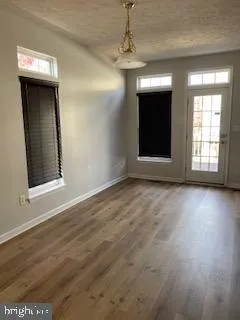 a kitchen with stainless steel appliances granite countertop a stove top oven a refrigerator a sink and dishwasher with wooden floor