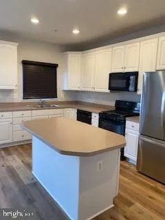 an empty room with wooden floor and cabinet