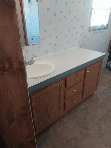 a bed sitting in a bedroom next to a cabinet