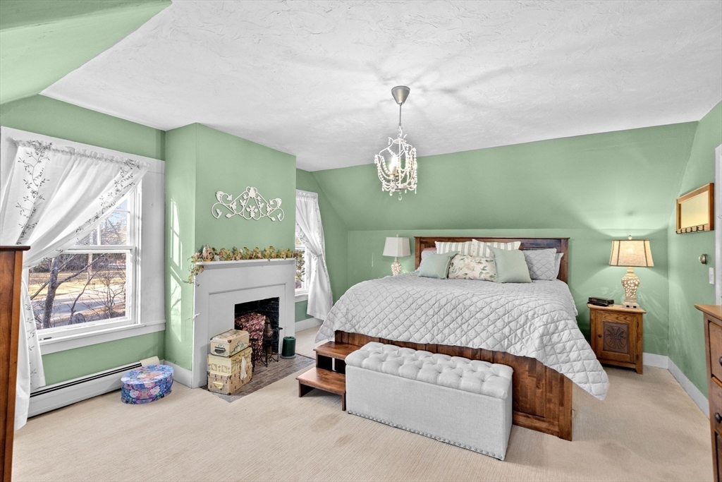 85 Summit Street Halifax, MA 02338 - Photo 20 of 42 a spacious bedroom with a bed a fireplace and a window