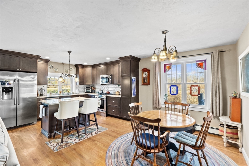 85 Summit Street Halifax, MA 02338 - Photo 26 of 42 a dining area with stainless steel appliances kitchen island granite countertop a dining table chairs and a refrigerator