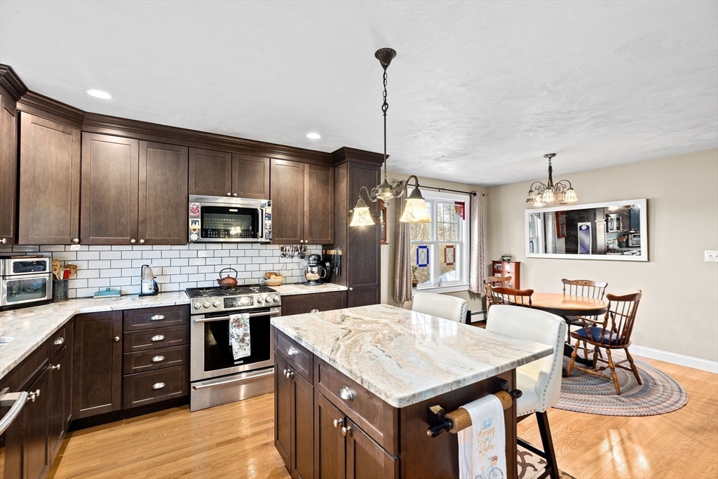 85 Summit Street Halifax, MA 02338 - Photo 27 of 42 a kitchen with stainless steel appliances kitchen island granite countertop a sink a stove a dining table and chairs