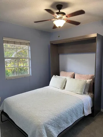 a bedroom with a large bed and a ceiling fan