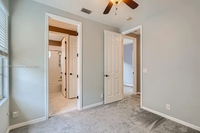 an empty room with closet and a chandelier fan