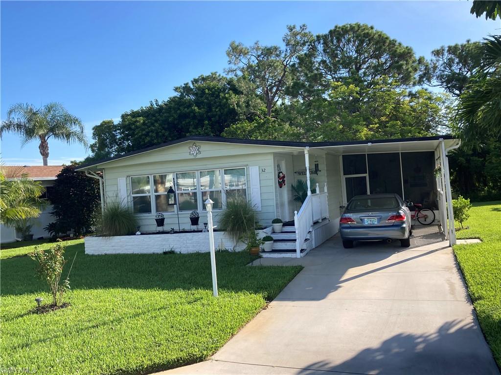 32 Lemans Drive Naples, FL 34112 - Photo 11 of 49 a front view of house with a garden and patio