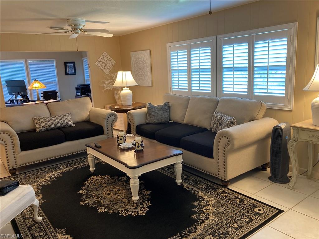 32 Lemans Drive Naples, FL 34112 - Photo 22 of 49 a living room with furniture a rug and a chandelier