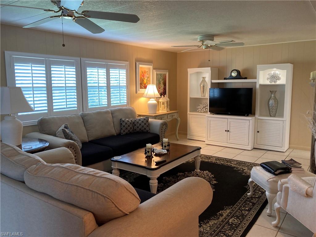32 Lemans Drive Naples, FL 34112 - Photo 23 of 49 a living room with furniture and a flat screen tv