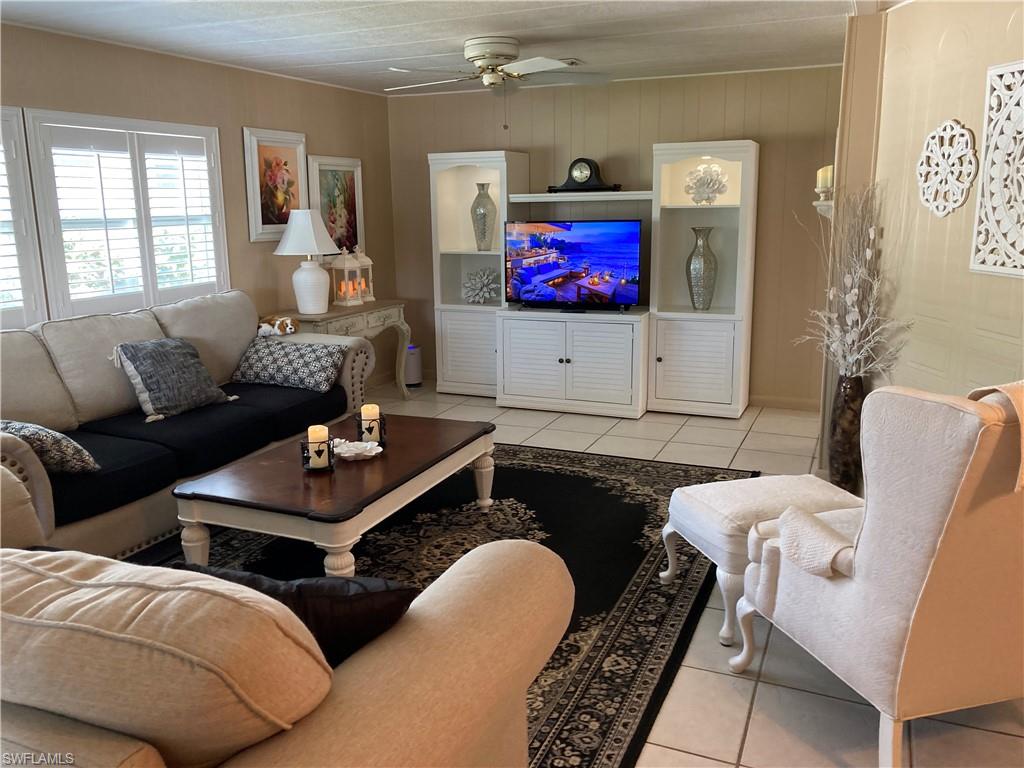 32 Lemans Drive Naples, FL 34112 - Photo 24 of 49 a living room with furniture and a flat screen tv