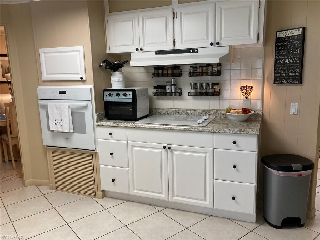 32 Lemans Drive Naples, FL 34112 - Photo 31 of 49 a kitchen with white cabinets and appliances