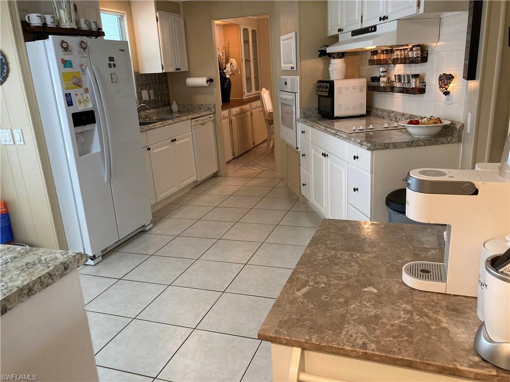 32 Lemans Drive Naples, FL 34112 - Photo 47 of 49 a kitchen with stainless steel appliances a sink a stove a refrigerator and cabinets