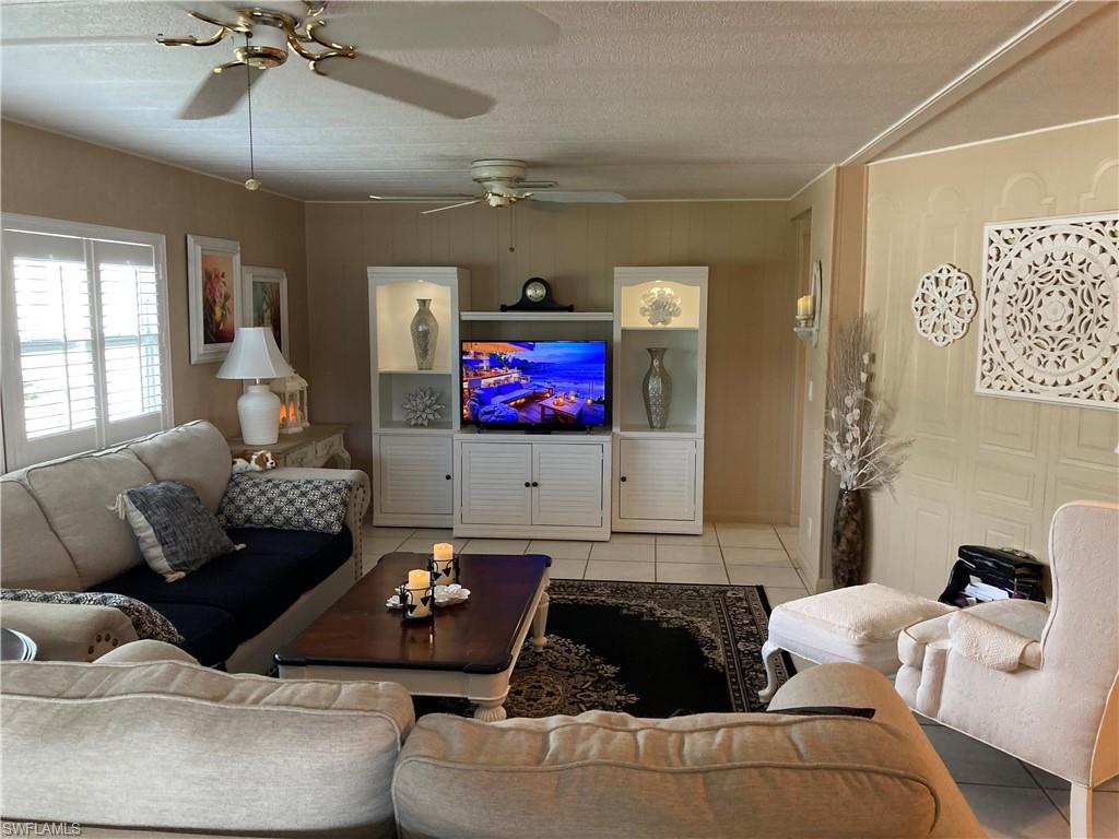 32 Lemans Drive Naples, FL 34112 - Photo 48 of 49 a living room with furniture and a flat screen tv