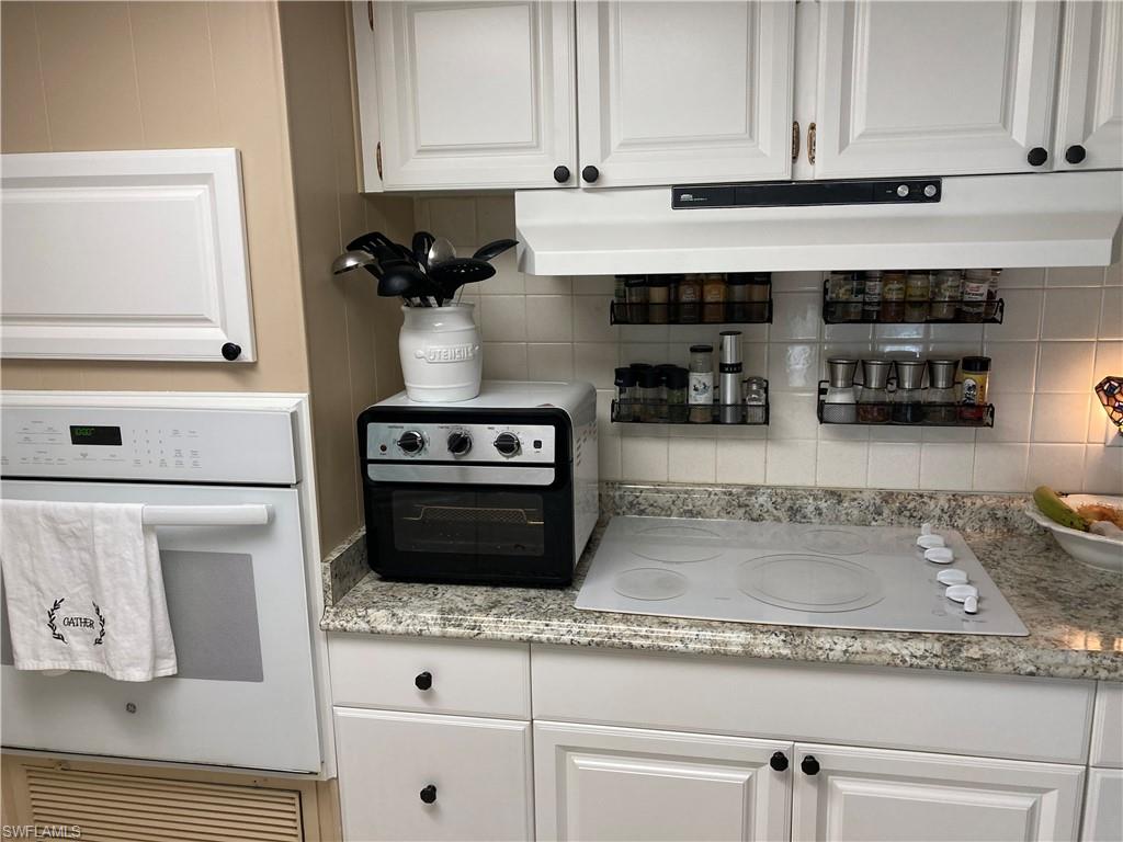 32 Lemans Drive Naples, FL 34112 - Photo 5 of 49 a kitchen with stainless steel appliances granite countertop a stove and a white cabinets