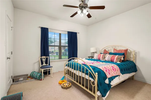 a bedroom with a bed a couch and a chandelier