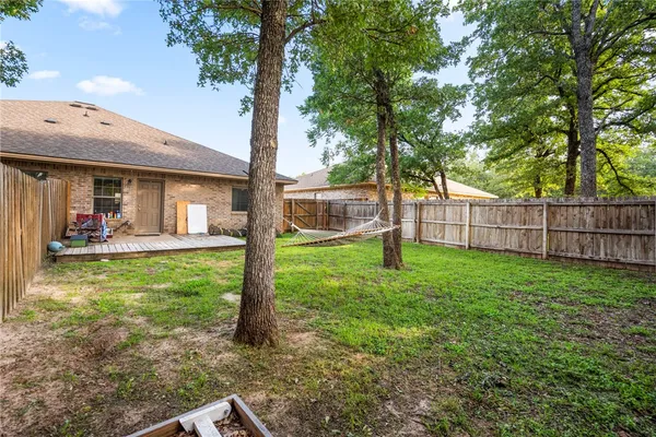 a view of a house with backyard and a tree