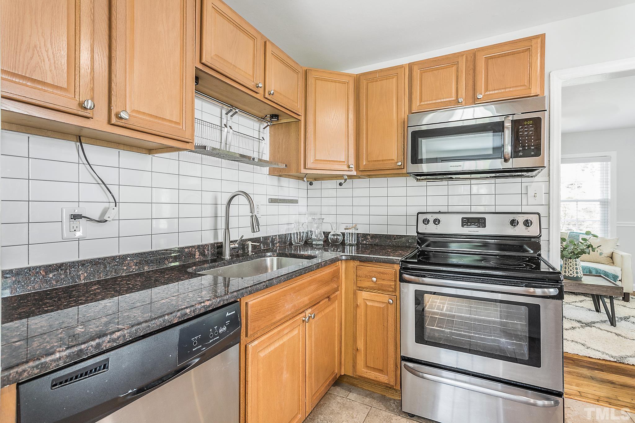 2222 Glascock Street Raleigh, NC 27610 - Photo 5 of 20 a kitchen with granite countertop a sink stainless steel appliances and cabinets
