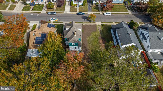 an aerial view of a residential apartment building with a yard and parking spaces