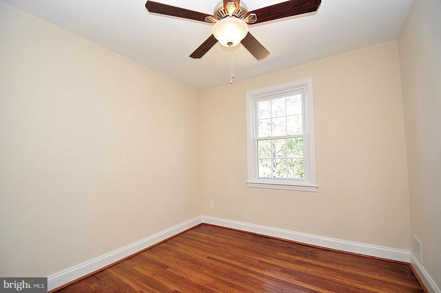1841 Loch Shiel Road Baltimore, MD 21286 - Photo 12 of 23 an empty room with wooden floor chandelier fan and windows